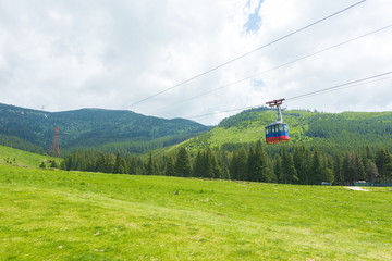 People in the cable car exploring the surroundings from the Carpathian Mountains