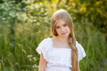 Fototapeta na wymiar Beautiful young girl with long blond hair with a bouquet in her hands. Girl walking in the countryside