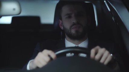 selective focus of tired businessman yawning and covering face while holding steering wheel, looking at car mirror and driving car 