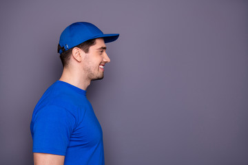 Close up side profile photo express specialist he him his delivery boy beaming smile self-confident took deliver order offer buy buyer wear blue t-shirt cap corporate suit isolated grey background