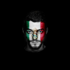 Flag of Mexico painted on a face of a man on black background.