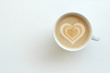 white wide cup of coffee, cappuccino with milk, cocoa with heart crema on a white table, top view, save space, close-up, concept of love