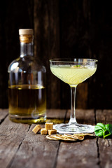 Liquor bottle, cocktail glass, brown sugar, basil leaves and dried lemon slices