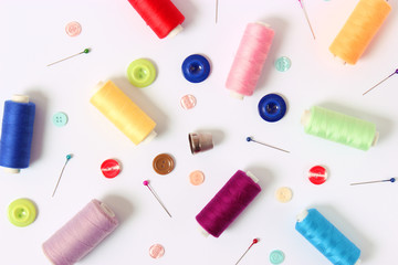 sewing accessories on white background top view.