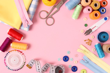 sewing accessories on a colored background top view.