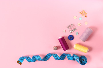 sewing accessories on a colored background top view.