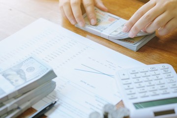 Businessman analyzing investment charts and pressing calculator buttons over documents. Accounting Concept.