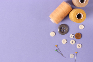sewing accessories on a colored background top view.