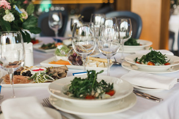 of the dishes and food on the served table.  long served feast table.festive table in the restaurant.Interior of the banquet hall in the cafe.banquet table in the restaurant.place of celebration