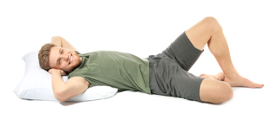 Handsome relaxed man with pillow on white background