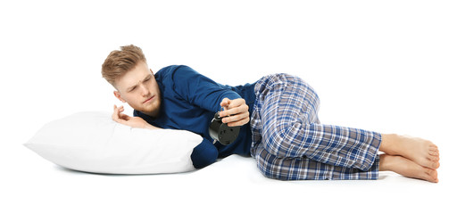 Sleepy man with alarm clock on white background