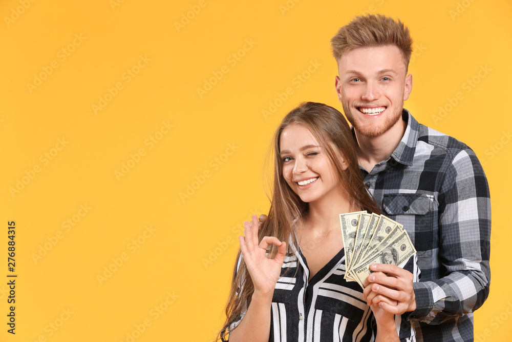 Canvas Prints Happy couple with money on color background