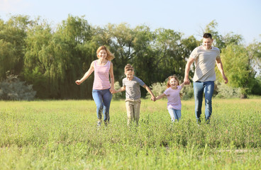 Happy family running in park on summer day