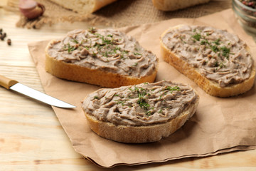 Fresh homemade chicken liver pate with herbs for bread on a natural wooden table. A sandwich.