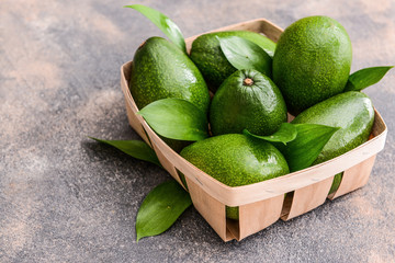 Box with fresh ripe avocados on grey background