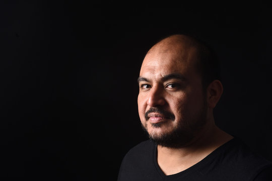 portrait of a latin american man on black background