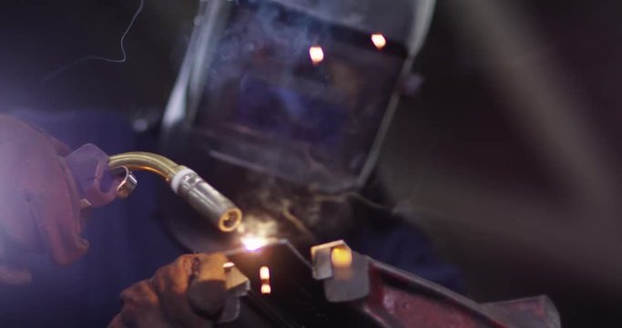 4K Close Up Of Smiling African American Female Welder At Work. Slow Motion.