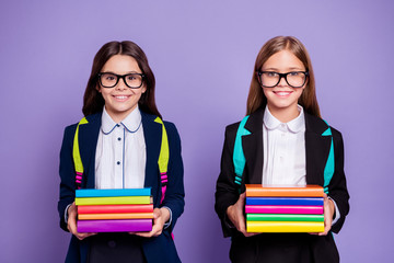 Portrait of cute schoolchildren hold hand literature preparation bag backpack rucksack isolated over purple background