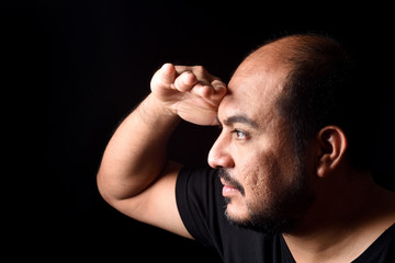 Fototapeta premium latin american man with hand in front looking away on black background