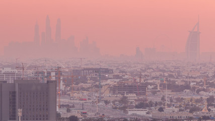 Fototapeta premium Sunset rooftop view on Dubai Marina with JLT skyline and Jumeirah beach in orange light, Dubai,United Arab Emirates