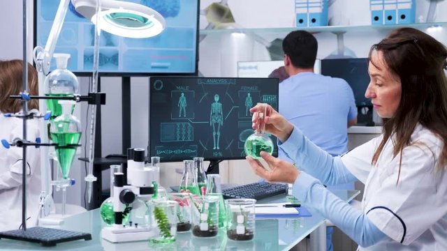 Zoom in shot of female scientist working in modern research center looking at test samples