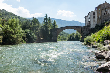 Fototapeta na wymiar Romanesque bridge with a single arch, in Gerri de la Sal, on the Noguera Pallaresa river. Catalan Pyrenees. Catalonia, Spain.
