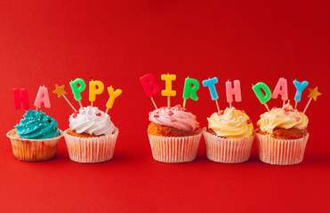 Happy birthday cupcakes on bright colored background