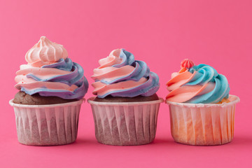 Tasty cupcakes sweets on pink background close up