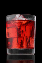 Red cocktail with ice cubes isolated on black