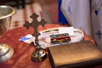 Isolated cross and bible on table. Orthodox church wedding accessories.