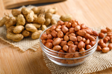 peanuts in bowl on the wooden background.