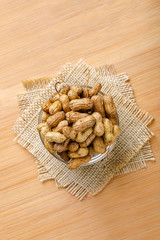 peanuts in bowl on the wooden background.