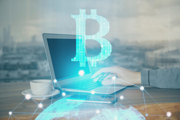 Obraz premium Crypto currency theme hologram with businessman working on computer on background. Concept of blockchain. Double exposure.