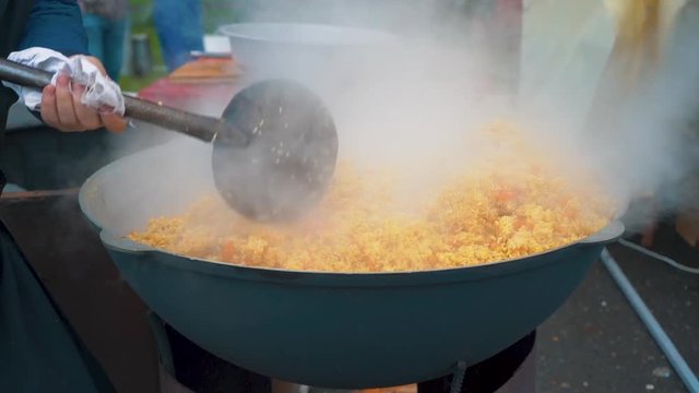 National Arab food. pilaf cooked in a large cauldron on the street. street food. celebration ramadan