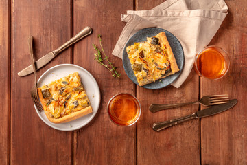 Slices of a zucchini and goat cheese pie with thyme and white wine, shot from the top on a dark rustic wooden background