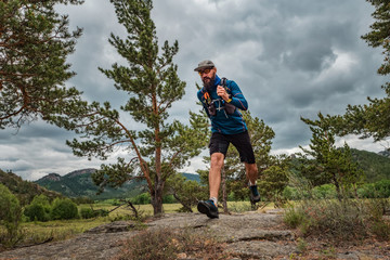 Male runner running on a mountain trail