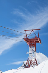 Mast und Seile der Gletscherbahn zwischen den hoch aufragenden Bergen