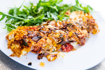 Omelete with arugula on white plate