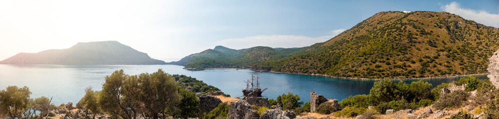 Pirate ship moored in a secluded bay with turquoise water at sunset, Oludeniz, Turkey panoramic