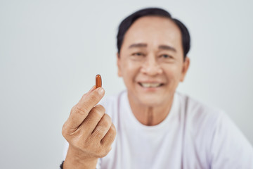 healthcare, madicine, pharmacy and elderly concept - old man with pills