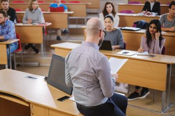 Lecturer and multinational group of students in an auditorium