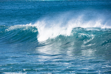 A wave breaking in the blue Atlantic ocean.