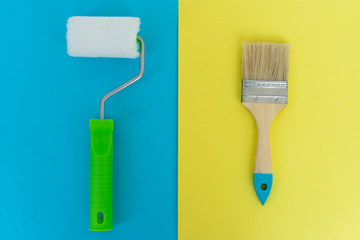 Painting brush and roller on blue and yellow background. Preparation for repair