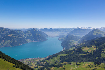 lake Lucerne with blue sky, Swiss alps, and village of Beckenried