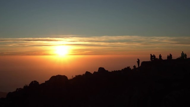 Beautiful silhouettes of people watching sunset from Table Mountain in Cape Town South Africa
