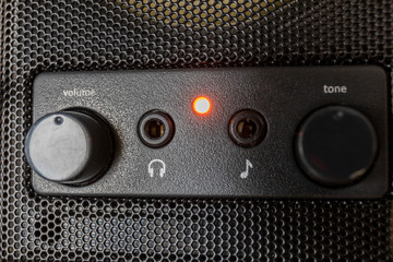 closeup of control panel of a loudspeaker with 3.5 mm jacks for phones and microphone