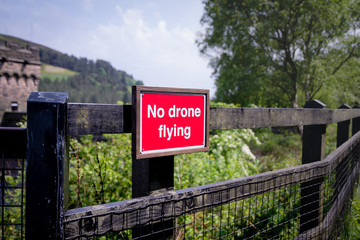Obraz premium A red No Drone Flying sign in the context of beautiful scenery