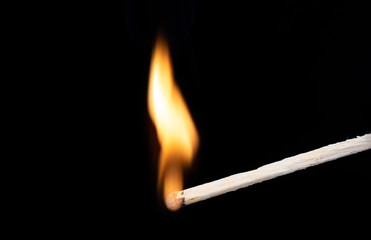 Curved flame of fire on a wooden match. Macro shot.