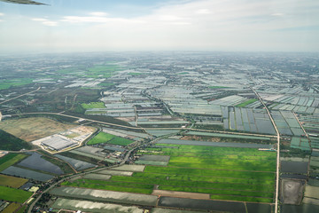 the view of green field and farm and city downtown in middle of Thailand. It shot from Jetplane.
