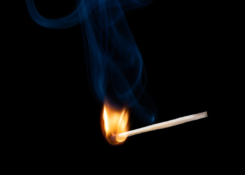 Wooden match with a sulfur head at the moment when it explodes.